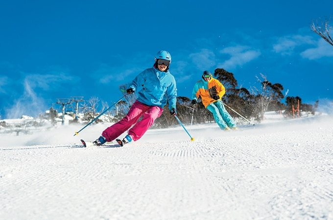 a couple with complete ski gear skiing at Thredbo Ski resort in New South Wales