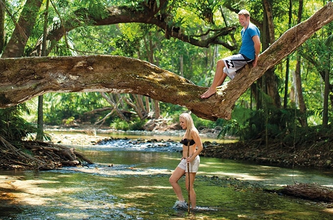 Couple trekking a river in Daintree Rainforest