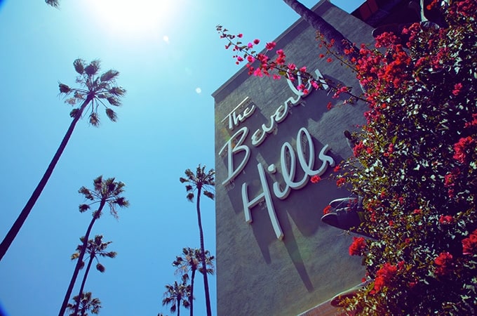 exterior shot of Beverly Hills Hotel's building with surrounding palm trees during daytime