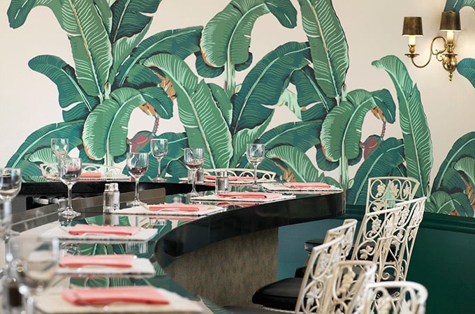 empty dining area or coffee room in Beverly Hills Hotel with curved counters and high bar stools with a banana leaf mural in the background