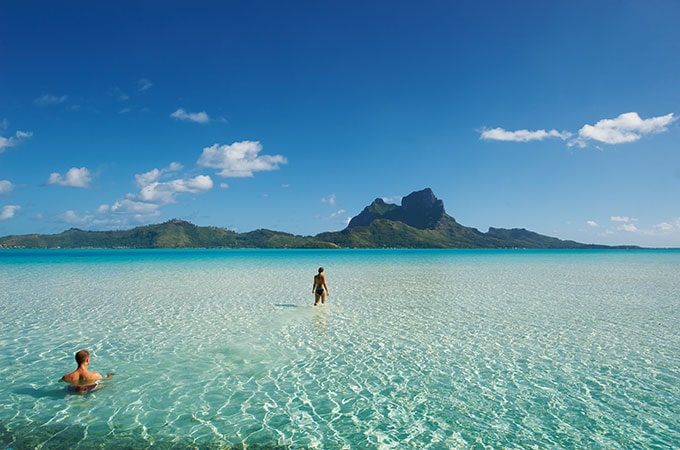 A couple enjoys the stunning beaches of Tahiti. Photo: Tim McKenna.