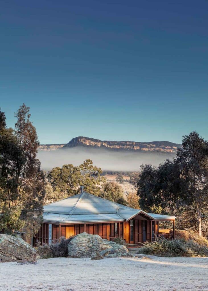 a lone wooden cabin with breathtaking views of the Blue Mountains with surrounding lush greeneries and trees