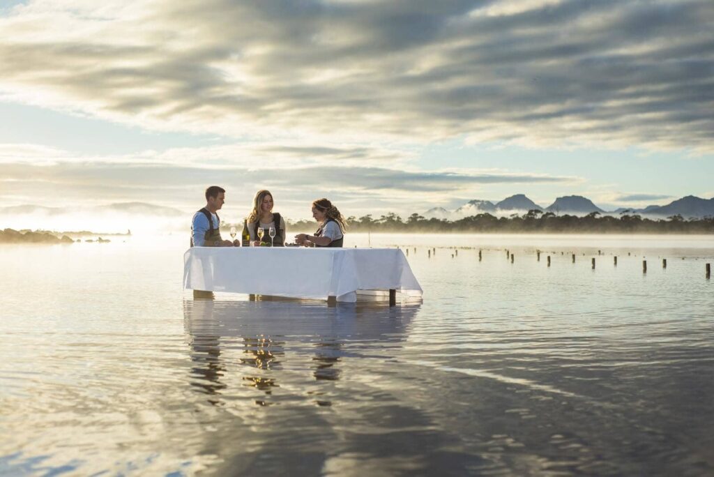 couple trying out an immersive oyster tasting in the middle of the sea at Saffire Freycinet in Tasmania