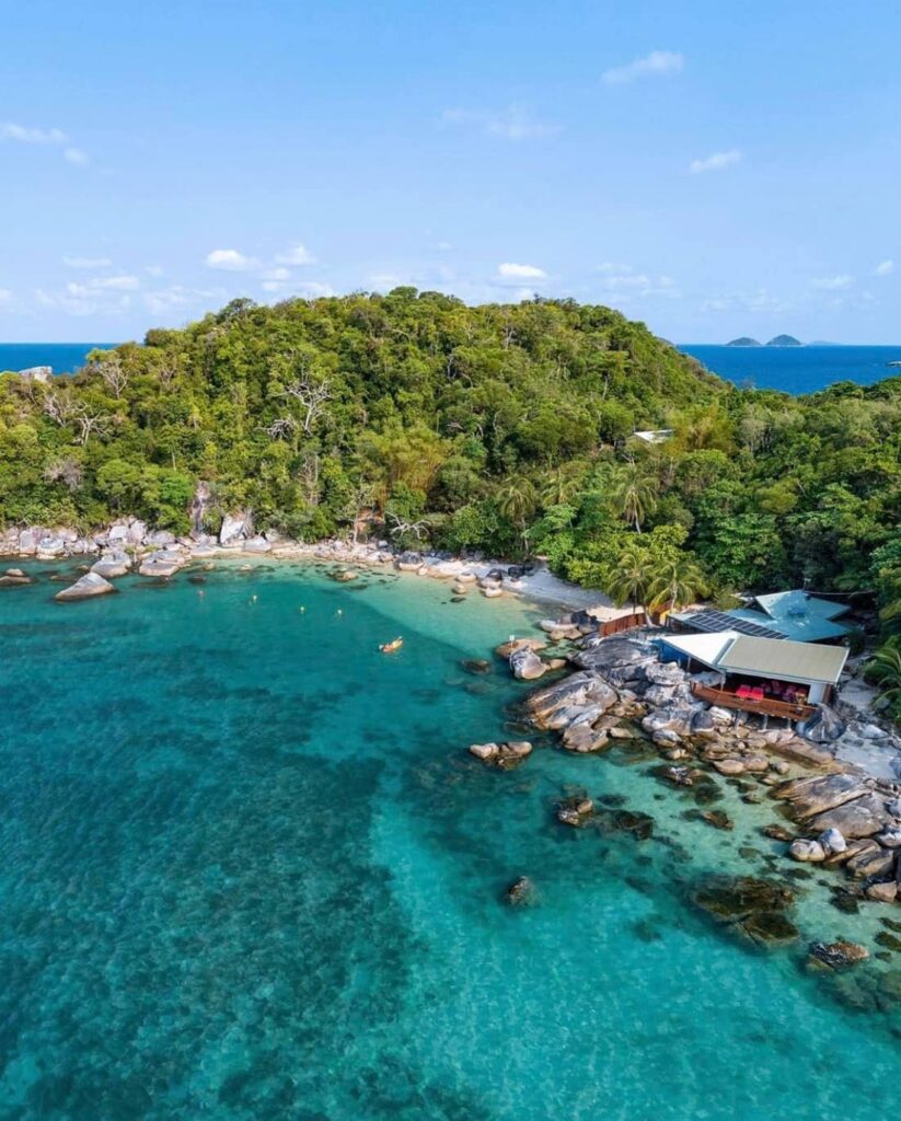 Aerial view of a resort cabin or villa in East Bedarra Island Queensland with beautiful clear water beach and surrounding lush greeneries and trees
