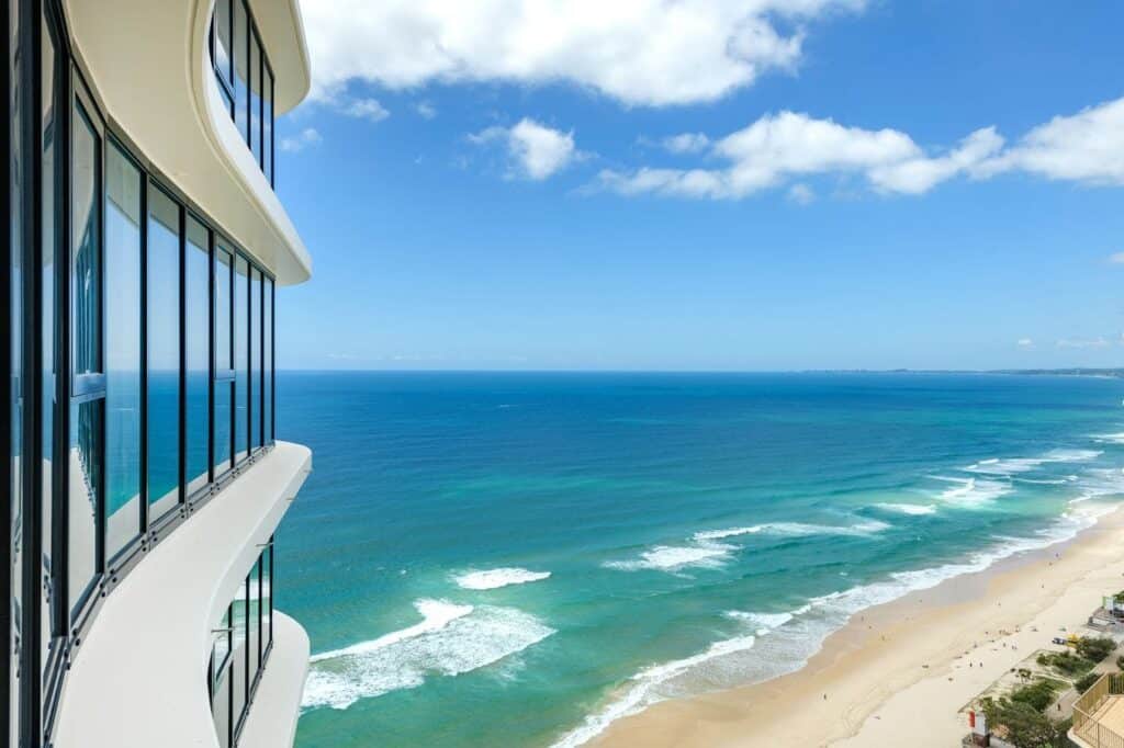 Aerial view of the waves crashing on the beach shore at Meriton Suites in The Gold Coast during daytime