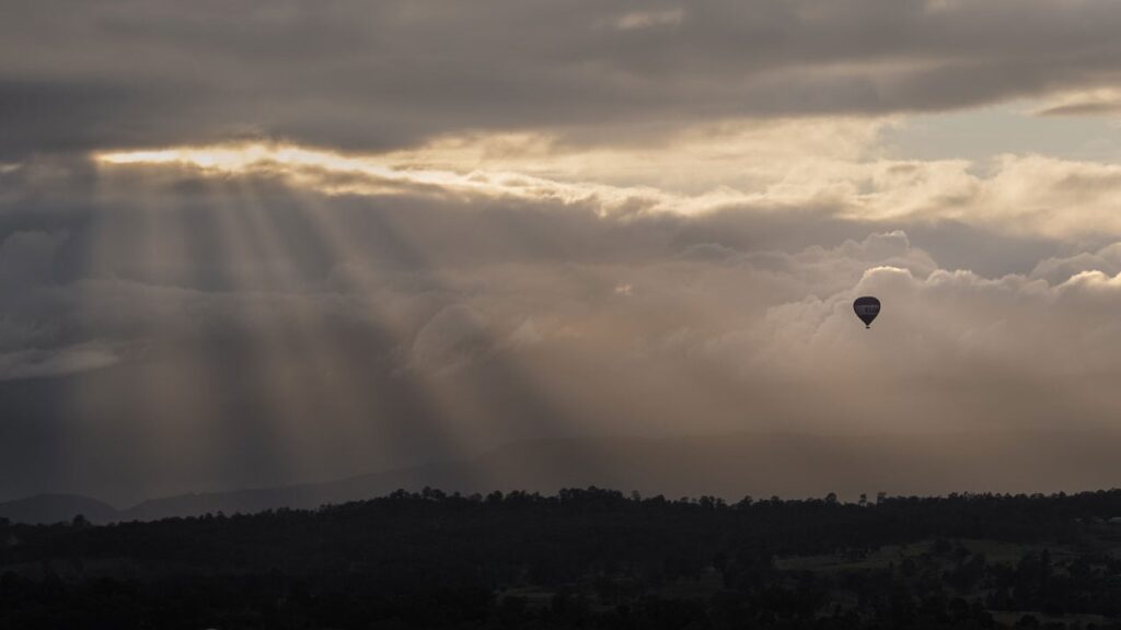 Hot-air balloon flying in The Gold Coast Hinterland during sunrise