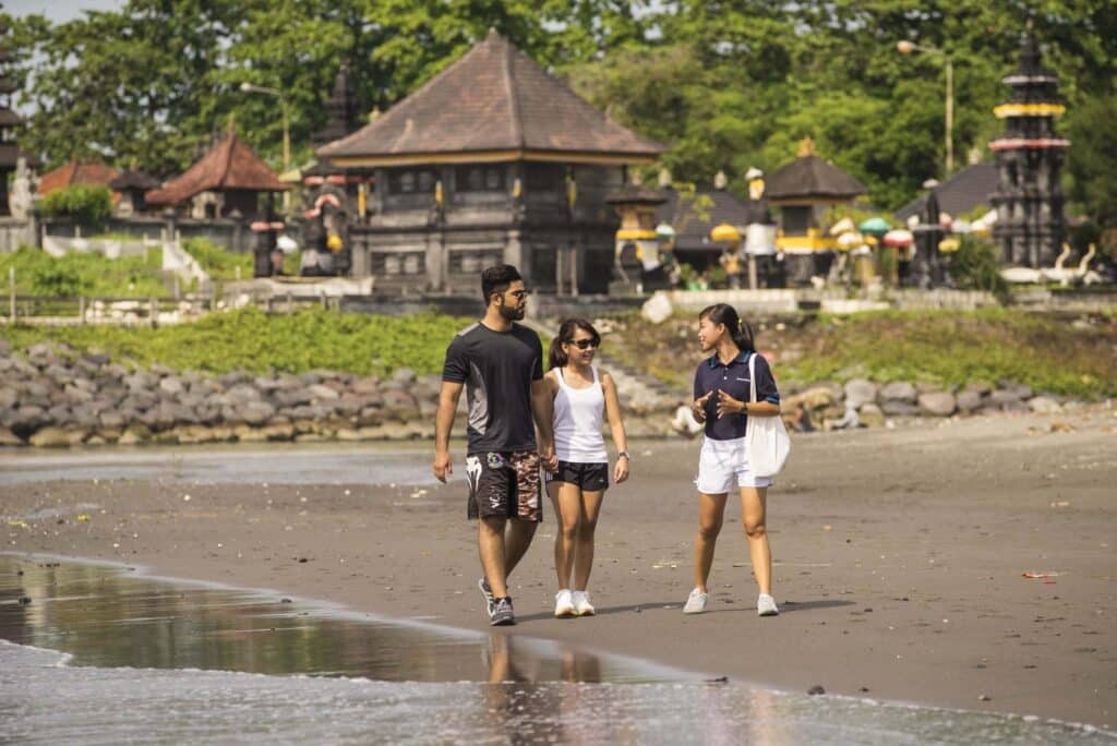 The-Samata-Sanur-Bali-couple-walking-on-the-beach-or-seashore-with-tour-guide