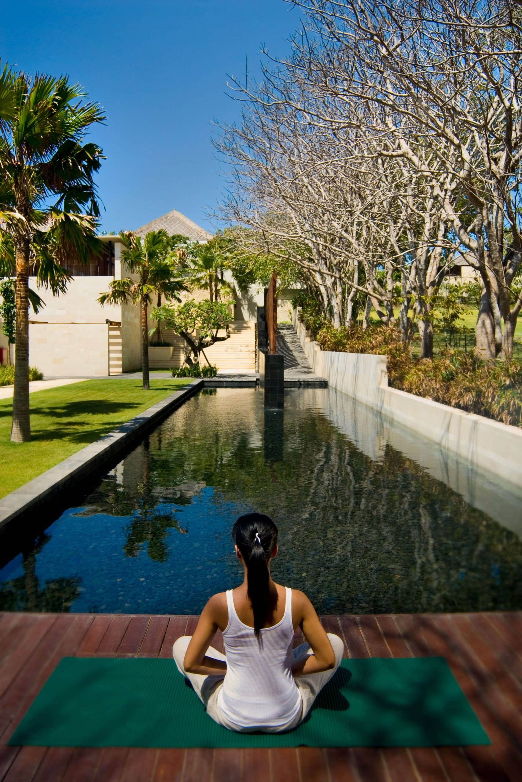 the-bale-nusa-dua-bali-girl-meditating-in-front-of-a-pool-during-daytime