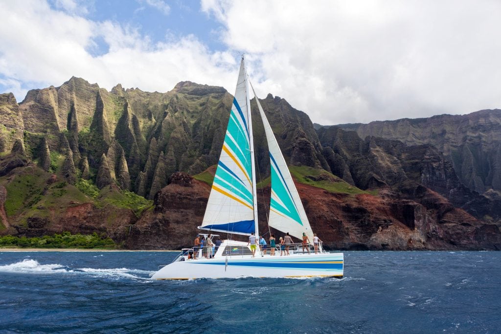 Niihau-Napali-Sailing-snorkeling-with-sailboat-and-mountains-in-the-background