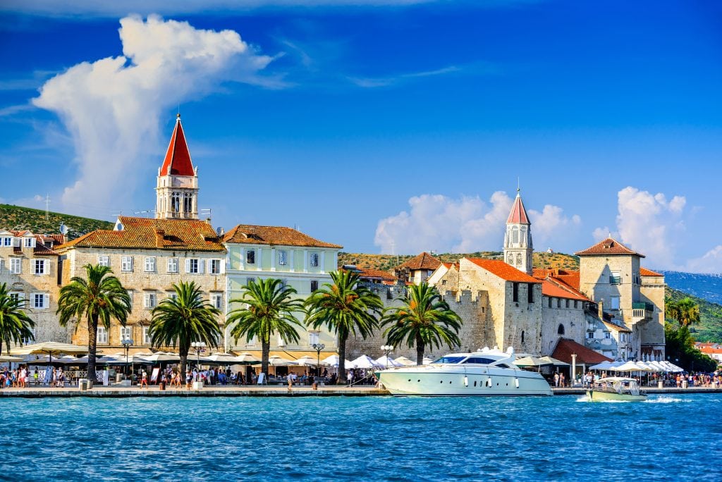 Europe-Trogir-Croatia-sea-on-the-foreground-palm-trees-busy-street-with-old-buildings-or-churches