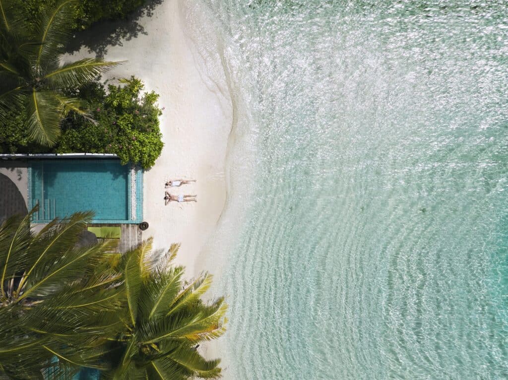 Centara-grand-island-resort-and-spa-maldives-drone-shot-of-a-couple-lying-down-on-the-beach-or-shore