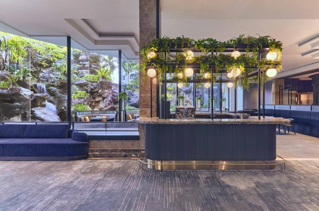 The orchard lobby bar with counters, seats, tables, and floor-to-ceiling glass windows or doors at the Vibe Hotel in Singapore