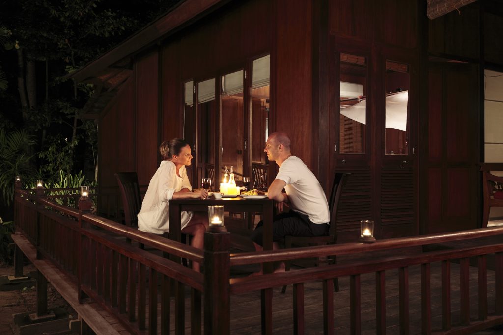 Romantic couple having a candle-lit dinner on the balcony of a villa at the Barefoot at Havelock Resort in the Andaman Islands