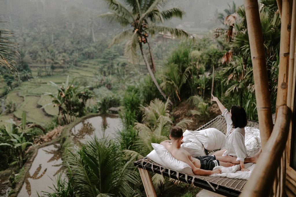 couple in bed looking out at vieew Ubud
