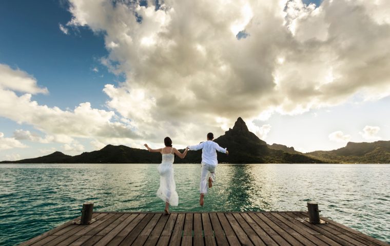 Couple jumping in water Bora Bora