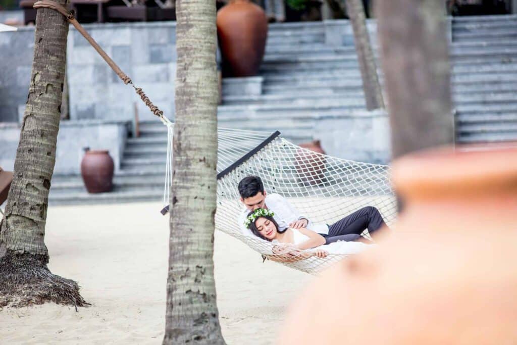 Four-Seasons-Resort-The-Nam-Hai-romantic-couple-on-a-hammock-by-the-beach