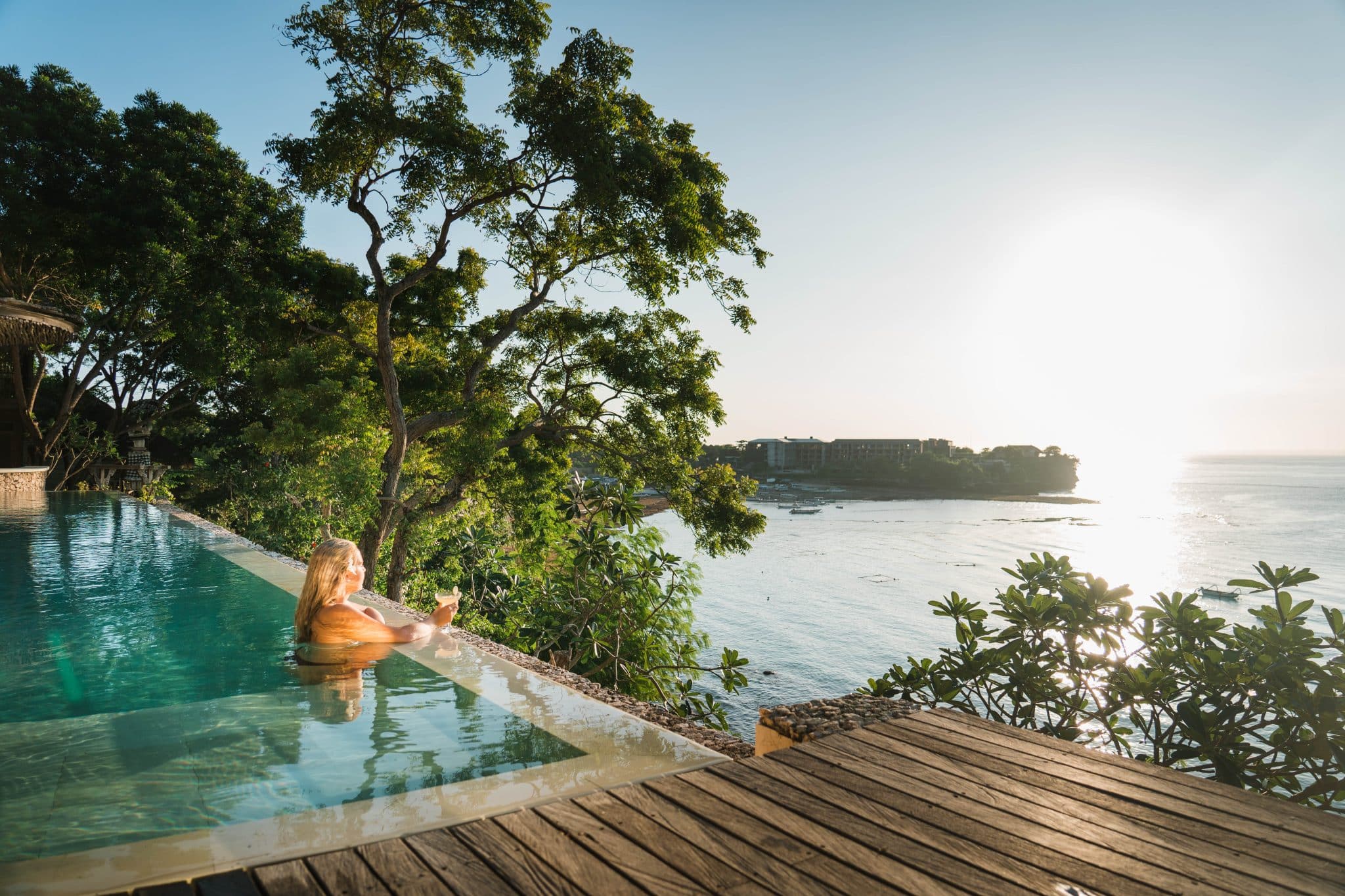 Morin Resort - Nusa Lembongan, Bali - woman swimming on the infinity pool with views of the beach